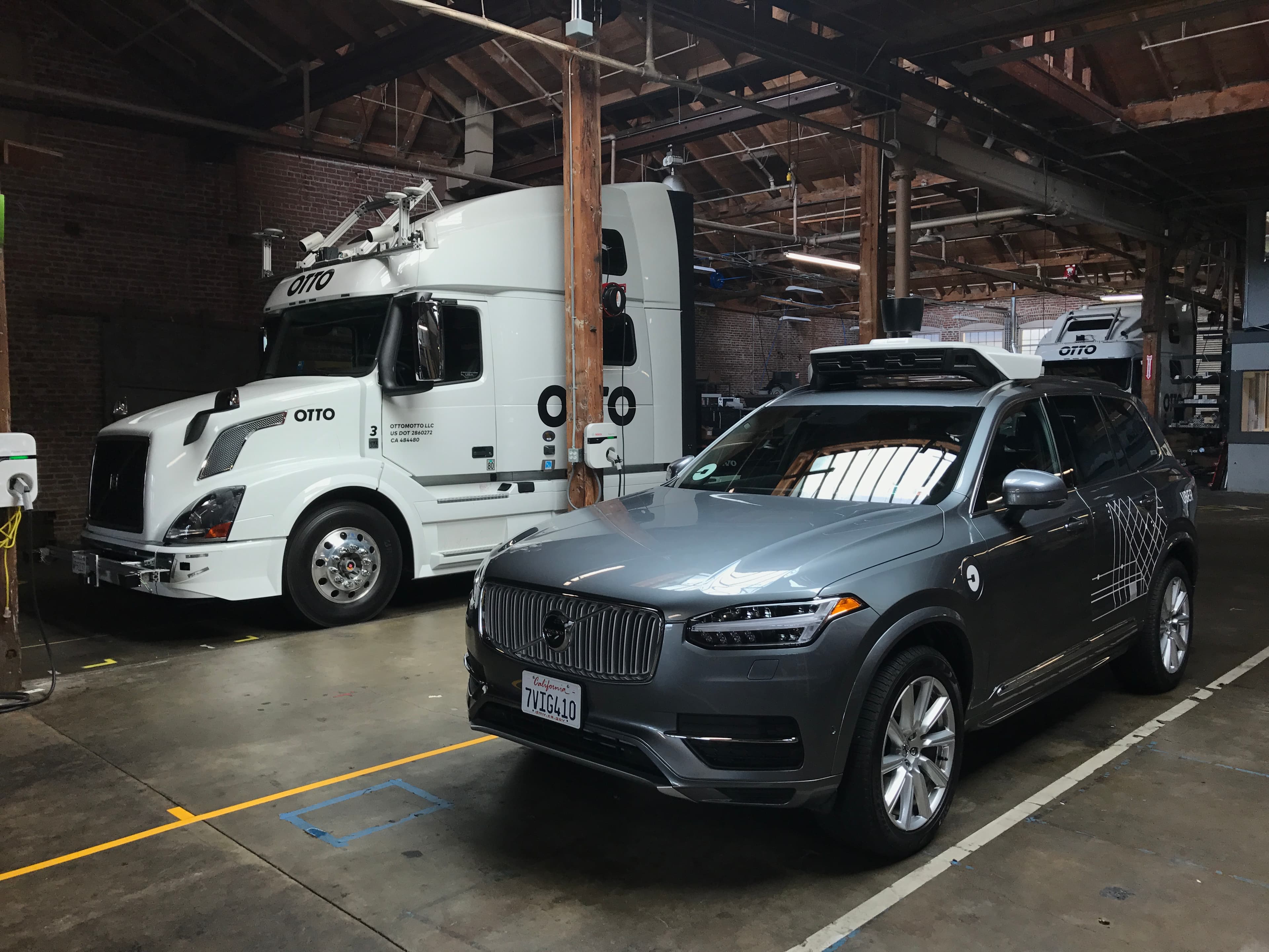 Otto autonomous truck alongside Uber's self-driving Volvo XC90